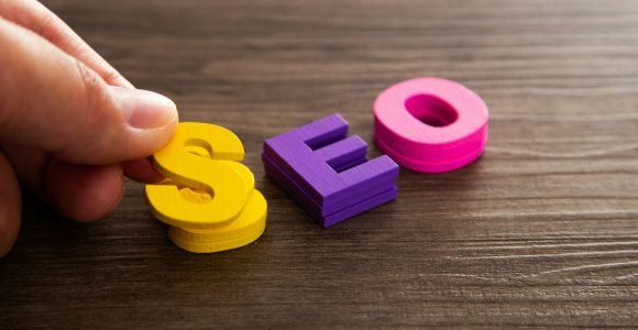 Hand arrange wood letters as SEO abbreviation